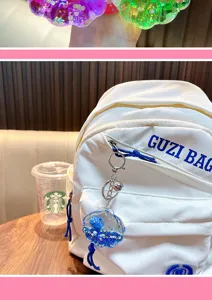 Détail d'un porte-clés coquillage bleu avec paillettes liquides suspendu à un sac