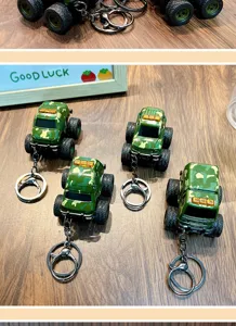 Detailed view of four camouflage off-road car toy keychains on a rustic wooden desk