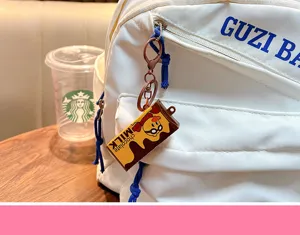 Detailed macro view of a chocolate bar stress relief keychain hanging on a white backpack zipper
