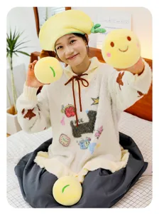 Nahaufnahme von einem Mädchen mit weichen gelben runden Smiley-Gesicht-Plüschkissen