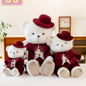 Collection of three white plush teddy bears wearing maroon wedding tuxedos and velvet hats