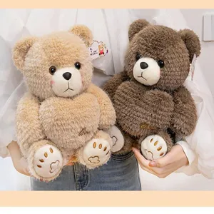 Close-up of two soft brown and beige plush teddy bears with embroidered heart details on bellies