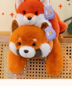 Detalle de lindos peluches de zorro naranja y panda rojo acostados en una silla de mimbre.