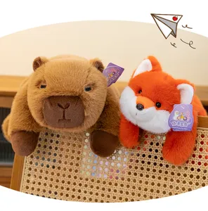 Primer plano de adorables peluches de carpincho y zorro en una silla de mimbre tejida