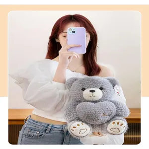 Adorable soft grey plush teddy bear holding a heart toy being held by a young model
