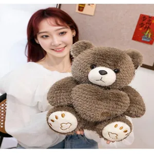 Detailed view of soft brown plush teddy bear holding a heart pillow decoration