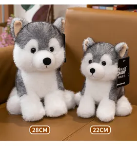 Detalle de dos adorables peluches husky de 28 cm y 22 cm en un sofá de cuero marrón