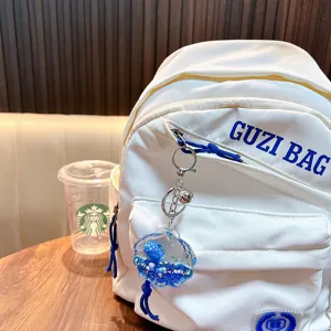 Porte-clés liquide bouteille flottante dauphin océan accroché sur un sac à dos blanc
