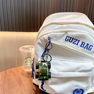 Cool camouflage monster truck off-road vehicle keychain hanging on a stylish white backpack