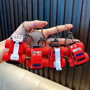 Collection of four red fire truck keychains featuring large off-road wheels and metal clips