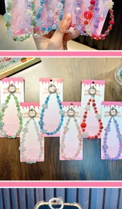 Detailed close-up of various colorful flower beaded crystal phone charms on display cards.