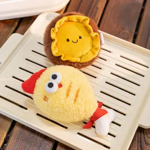Close-up of cute plush fried chicken and round character keychains resting on a tray.