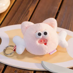 Macro view of a cute pink plush pig keychain with wings and silver metal ring charm.