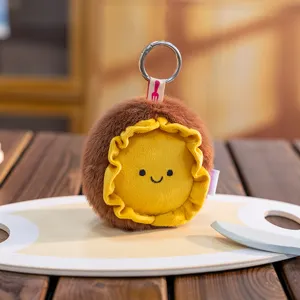 Close-up of a cute plush round keychain with a smiling face and ruffled yellow edge