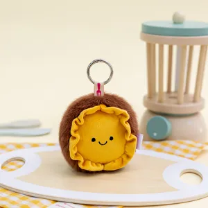 Detail view of a cute round plush keychain featuring a smiley face and yellow ruffled border