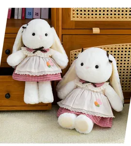 Detailed view of two cute white long-eared plush rabbits wearing pink checkered dresses