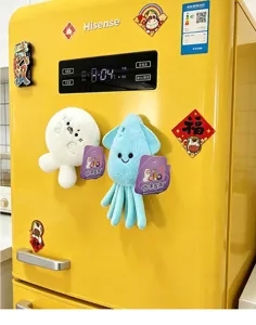 Detailed view of plush marine animal refrigerator magnets on a yellow surface