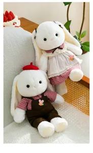 Detailed macro view of couple long-eared plush bunny dolls wearing adorable outfits for gifting