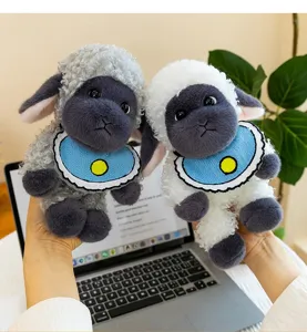 Adorable black-faced sheep plush toy with curly fur and blue bib in a laptop setting