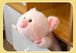 Primo piano di un simpatico maialino di peluche rosa che spunta da un cassetto bianco