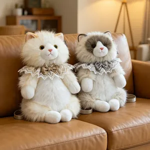 Detail view of two plush cat backpacks with elegant lace collars on a leather sofa