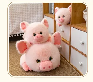 Una collezione di tre morbidi peluche di maialini rosa in varie misure su tappeto