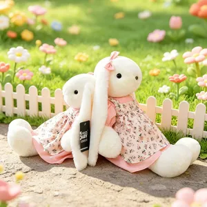 Paar schattige witte konijnenknuffels in roze bloemenjurken in een tuinsetting