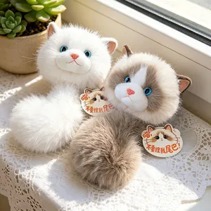 Dos suaves colgantes de monedero de peluche de gato ragdoll sobre encaje blanco al sol
