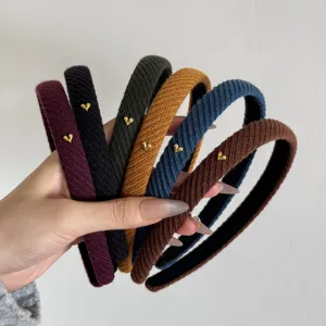 Dettaglio delle fasce in maglia a coste con piccoli ornamenti a forma di cuore d'oro.