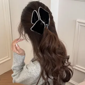 Detail view of elegant black velvet hair scrunchie with rhinestones on wavy hair