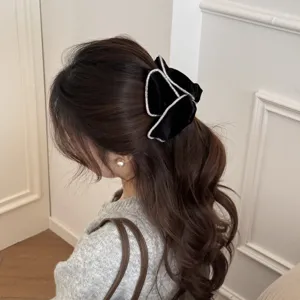 Elegant velvet hair bow with rhinestones on a wavy ponytail, luxury hair accessory.