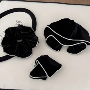 Close-up detail of black velvet hair accessories with sparkling rhinestone edges