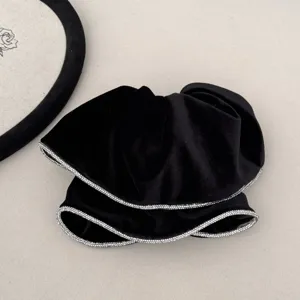 Close-up of elegant black velvet hair scrunchie with sparkling rhinestone edges