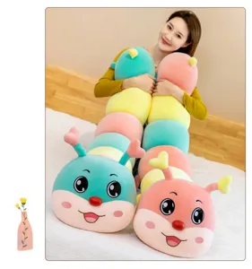 Detail of a model holding two long colorful caterpillar plushies in a bedroom setting.