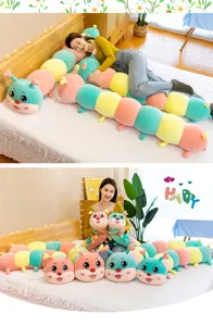 Soft colorful caterpillar plush long pillow shown in a cozy bedroom setting with model