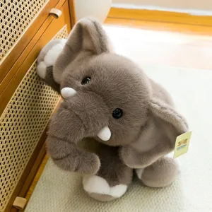 Cute grey elephant plush toy with soft fur and big ears in home setting