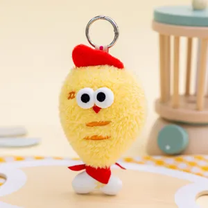Close-up of a cute yellow plush bird keychain with red beret and scarf details.
