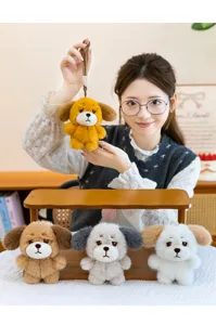 Detailed view of cute sad dog plush keychains in four colors held by a female model.