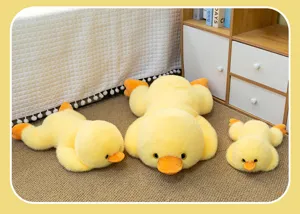 Detailed view of three sizes of yellow duck plush toys lying on a brown carpet in a cozy room.