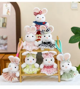Group of cute plush rabbit keychains wearing colorful checkered dresses on a wooden shelf