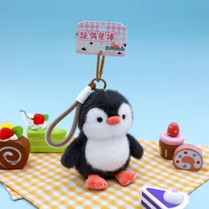 Cute black and white plush penguin keychain with hanging strap detail