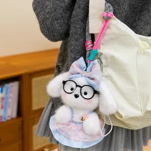 Adorable white plush puppy keychain with glasses and bow pendant on a canvas bag