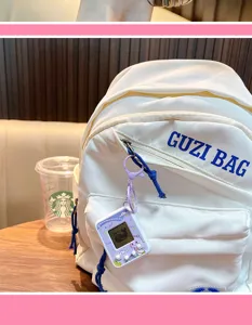 Detailed view of a purple mini virtual electronic pet keychain hanging on a white backpack