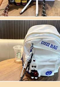 Lockiger Pudel Plüsch Schlüsselanhänger als stilvoller Taschenanhänger an einem Rucksack