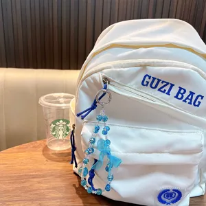 Ciondolo in perle di cristallo blu con fiocco per accessorio zaino bianco