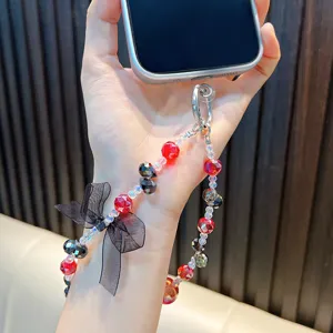Elegante ciondolo per cellulare con perline, cristalli rossi e un raffinato fiocco nero.