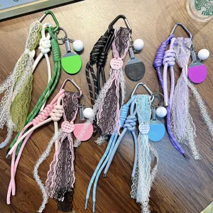 Bunte Tischtennisschläger-Schlüsselanhänger mit Spitzenbändern und Paracord auf einem Holztisch