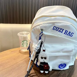 Niedlicher lockiger Plüsch-Teddyhund Schlüsselanhänger als Taschenanhänger an einem Rucksack