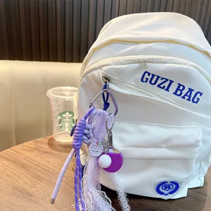 Niedlicher lila Tischtennis-Schlüsselanhänger mit Spitze an einem weißen Rucksack