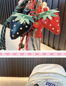 Close-up detail of strawberry leather bag charms with colorful braided cords and tassels